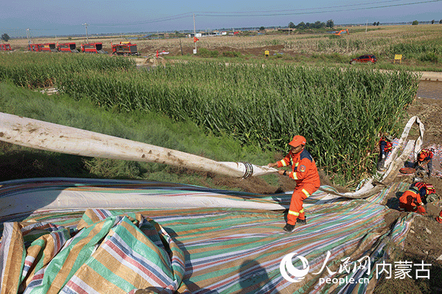 救援队员铺设排涝设备。韩松源摄